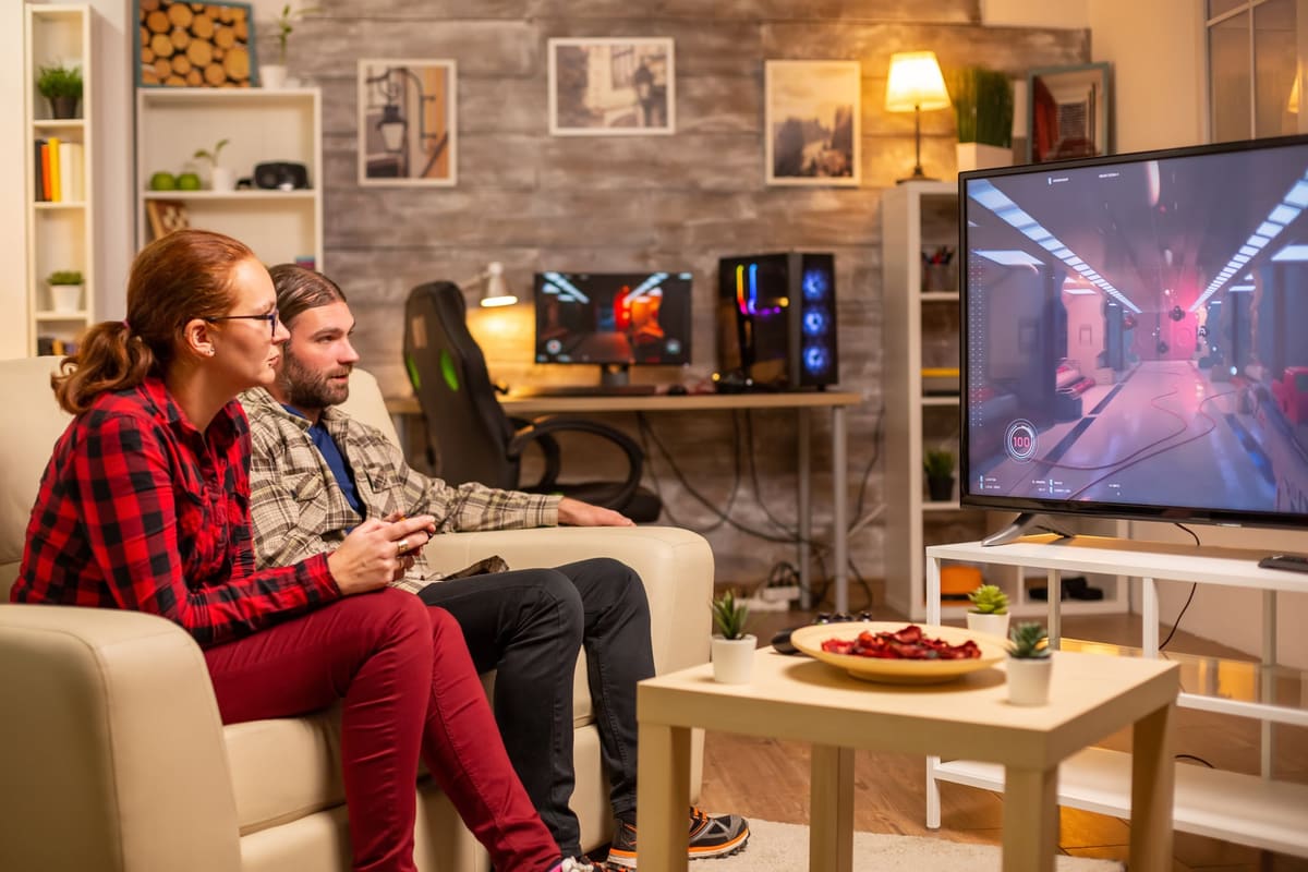 A couple playing video games on a big-screen TV in a living room