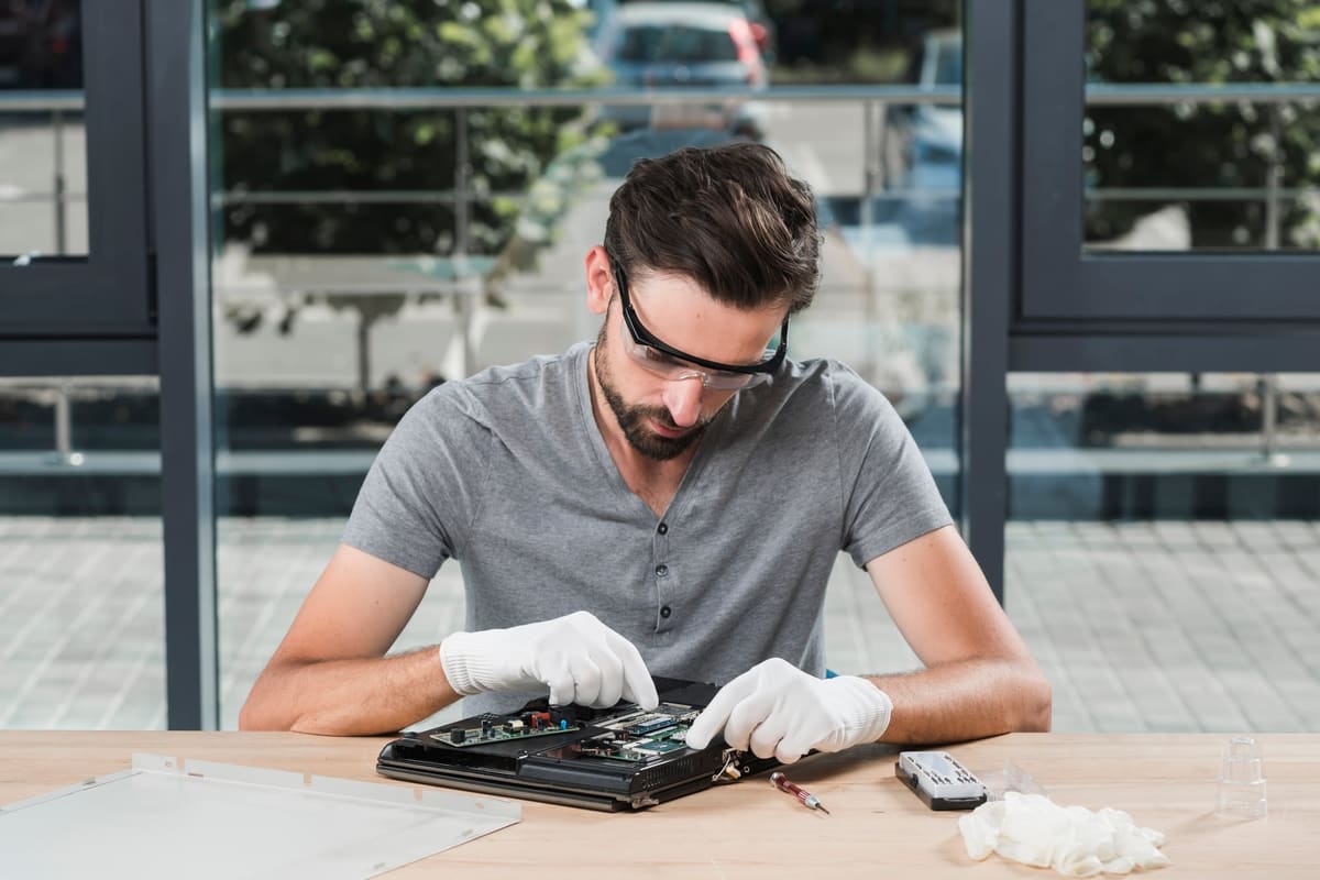 A young technician repairing a computer in a workshop