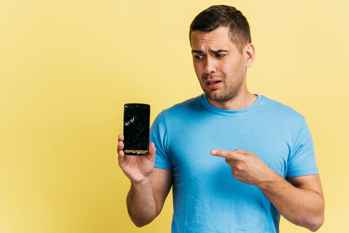 A man holding a broken smartphone