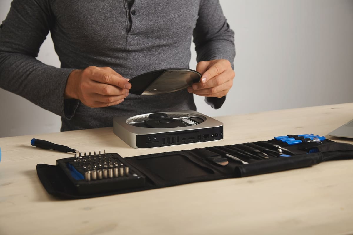 A technician opening a small computer to upgrade its memory