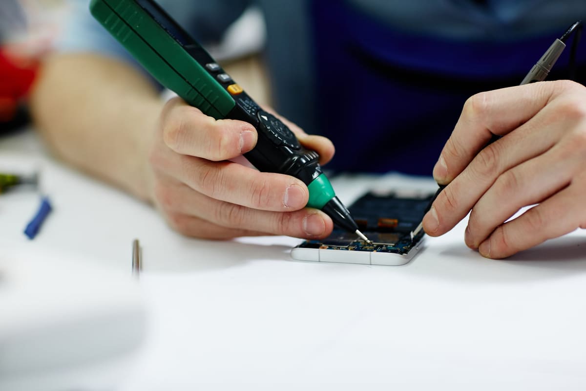 A technician testing the voltage of a mobile device